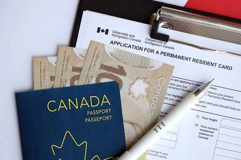 Application for permanent resident card on table with pen and canadian passport Stock Photos