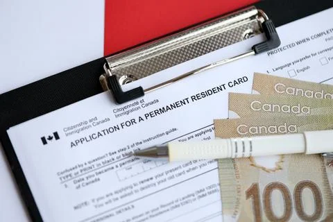 Application for permanent resident card on table with pen and canadian money Stock Photos