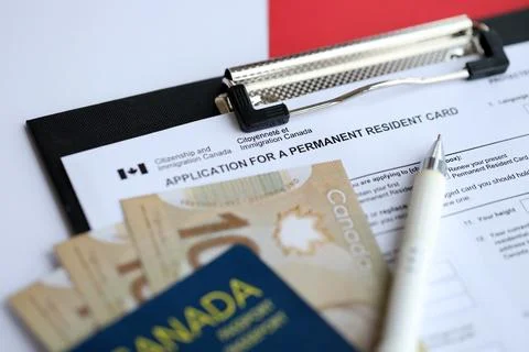 Application for permanent resident card on table with pen and canadian passport Stock Photos