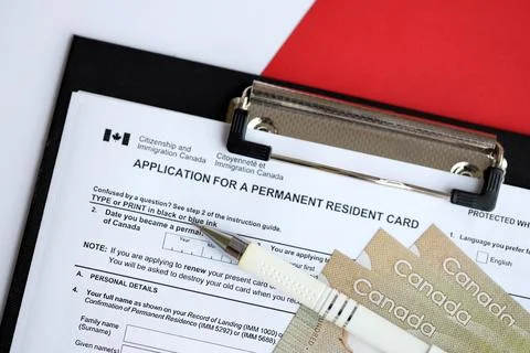 Application for permanent resident card on table with pen and canadian money Stock Photos