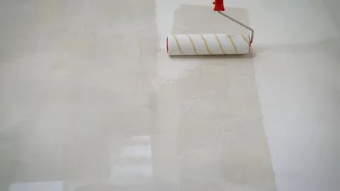 Application of primer on drywall - paint roller white paint - construction. 스톡 사진
