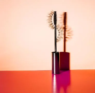 Applicator mascara and false eyelashes with drop shadow on orange background Stock Photos