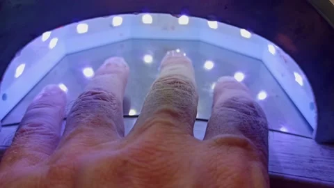 The applied gel on the fingernails is dried under a lamp Stock Footage 161888501