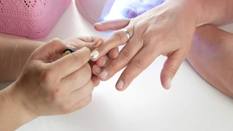 Applies the second layer of the product.Dries the varnish in a UV lamp with LEDs 스톡 동영상 138582192