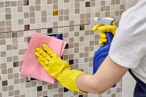 Apply cleaning agent to water button in the toilet and wipe with cleaning cloth. Stock Photos