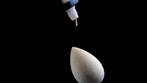 Apply foundation on a sponge. Black background. Close-up. Stock Footage 122200266