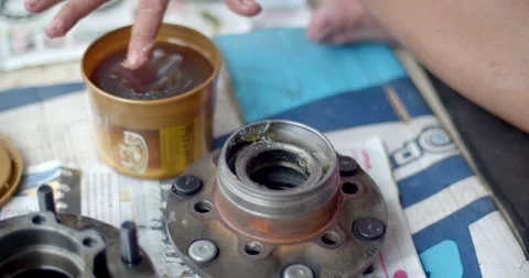 Apply grease to the wheel hub after inserting the bearings. Stock Footage 277414932