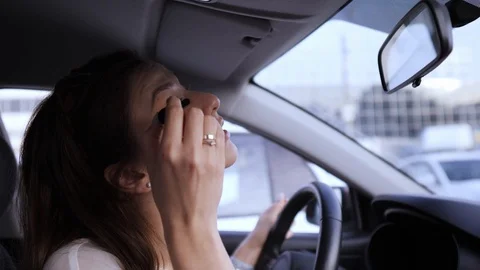 Apply mascara using a brush. Illegal driving. Beautiful young woman looks in the Stock Footage 120950892