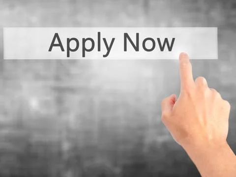 Apply Now - Hand pressing a button on blurred background concept on visual sc Stock Photos