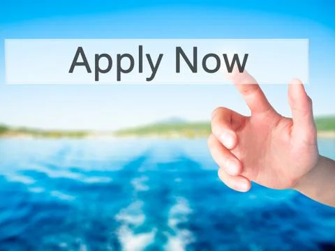 Apply Now - Hand pressing a button on blurred background concept on visual sc Stock Photos