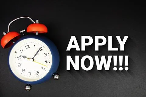 Apply Now text with alarm clock on black background Stock Photos