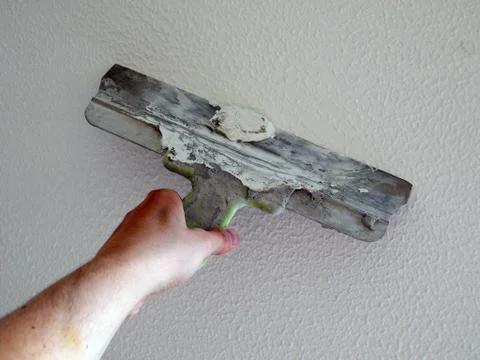 Apply the putty on the wall with a spatula Stock Photos