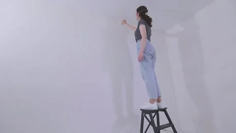 Apply wallpaper paste to the wall with a roller or brush. Applying wallpaper Stock Footage 331959440