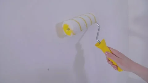 Apply wallpaper paste to the wall with a roller or brush. Applying wallpaper Video stock 333705417