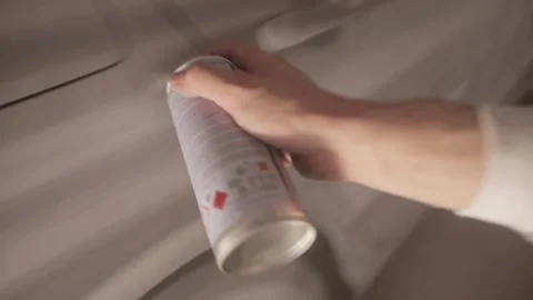 Applying airbrushing to a passenger car in a paint booth using a spray can Stockbeeldmateriaal 304110586