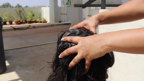 Applying and massaging the head with coconut oil mixed with fenugreek seeds Stock Footage 238847346