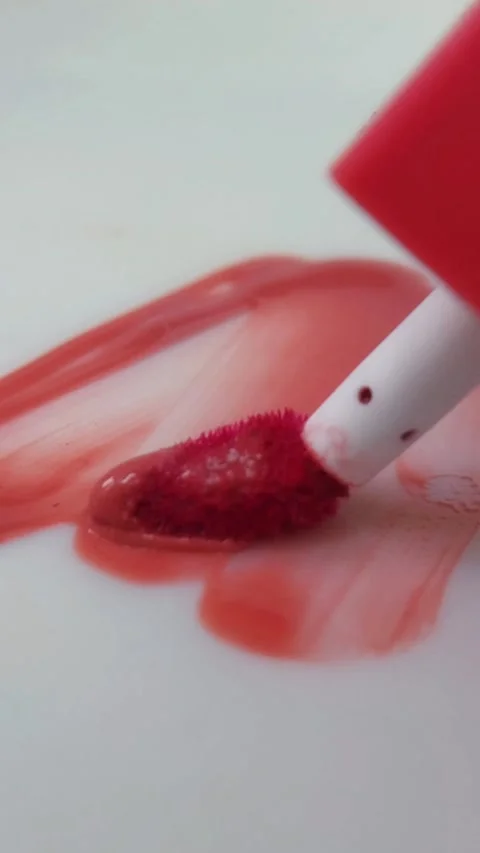 Applying and spreading red lip tint on a white background in a zigzag motio.. Stock Footage 332227171