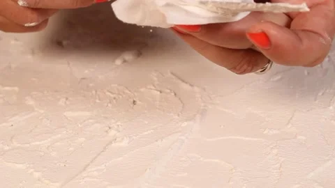 Applying an artistic white textured plaster with a small metal palette knife Stock Footage 135751449