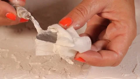 Applying an artistic white textured plaster with a small metal palette knife Stock Footage 135751474