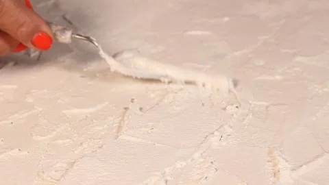 Applying an artistic white textured plaster with a small metal palette knife Stock Footage 135751726