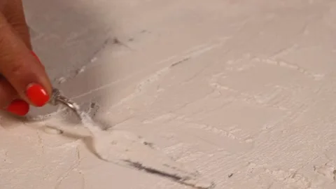 Applying an artistic white textured plaster with a small metal palette knife Stock Footage 135751790