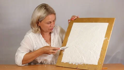 Applying an artistic white textured plaster with a small metal palette knife Stock Footage 135751930