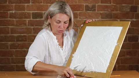 Applying an artistic white textured plaster with a small metal palette knife Stock Footage 135751985