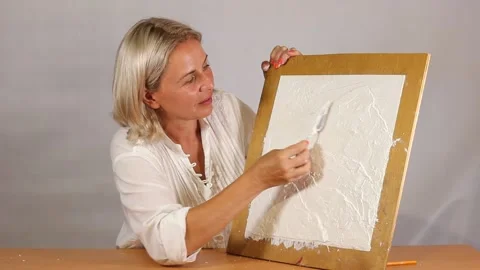 Applying an artistic white textured plaster with a small metal palette knife Stock Footage 135752030