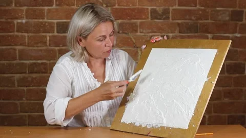 Applying an artistic white textured plaster with a small metal palette knife Stock Footage 135752149
