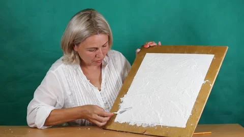 Applying an artistic white textured plaster with a small metal palette knife Stock Footage 135752300