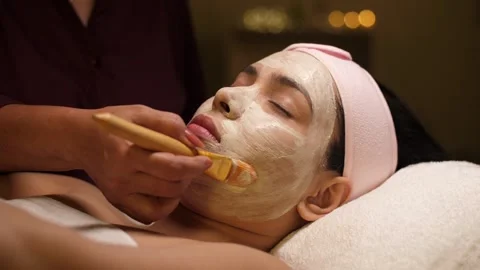 Applying avocado face mask with a brush - spa treatment, relaxing routine, de... Stock Footage 259821078