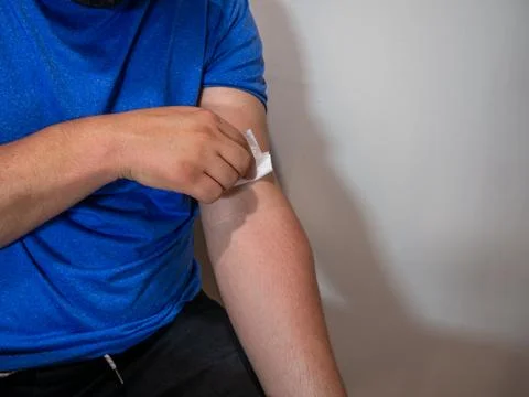Applying Bandage After Injection in Arm Фото