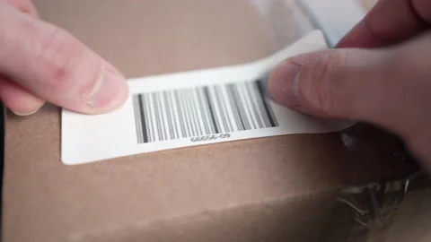 Applying a Bar Code Label on a Cardboard Box Closeup Stock Footage 185112538