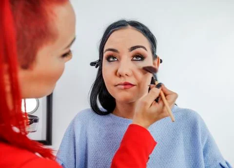 Applying a bit of red colour on her cheeks Stock Photos