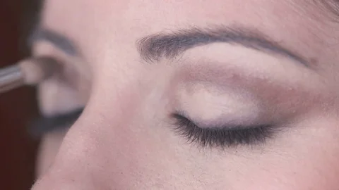 Applying  brown eye shadow On beautiful woman's Eyes Stock Footage 74705320
