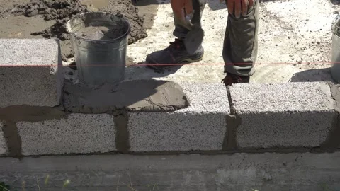 Applying Cement Mortar to Cinder Blocks During Wall Construction Stock Footage 314308720