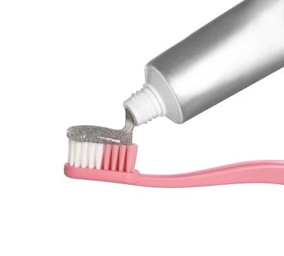 Applying charcoal toothpaste on brush against white background 스톡 사진
