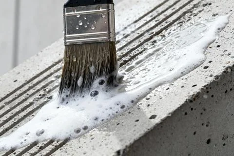 Applying a cleaning solution to concrete with a brush for maintenance Stock Photos