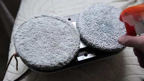 Applying Cleaning Spray to Robotic Window Cleaner Microfiber Pads Stock Footage 331876554