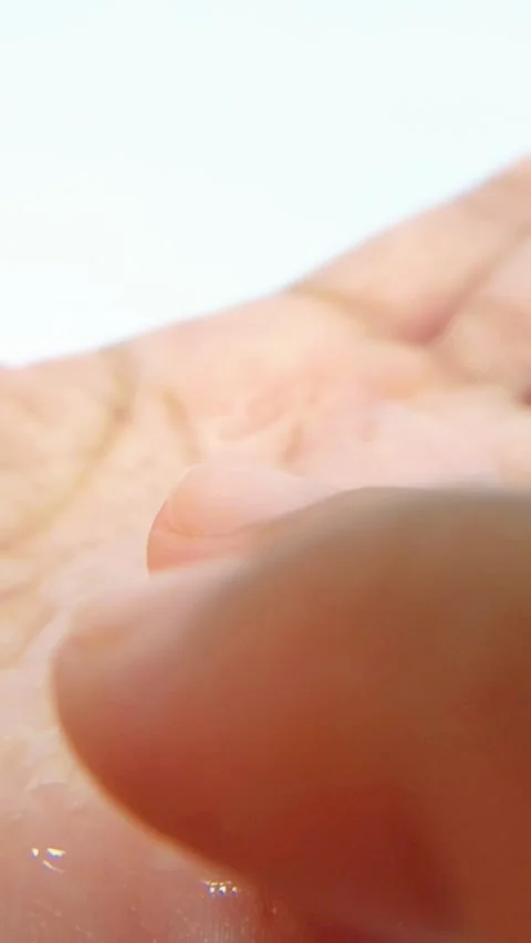 Applying clear liquid with finger on palm of hand. Close up view, white bac.. Vídeo Stock 335022442