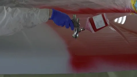 Applying a coat of red car paint with an airbrush Stock Footage 77109713