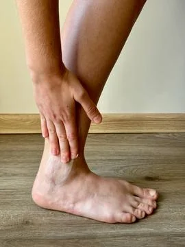 Applying cream by hand to a healing after surgery scar on the right ankle Stock Photos