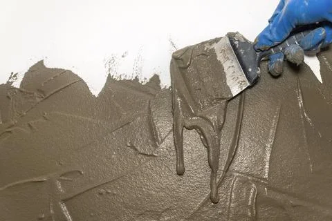 Applying decorative plaster to a wall with a spatula. Stock Photos