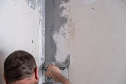 Applying decorative putty. White abstract texture of surface covered with putty Stock Photos