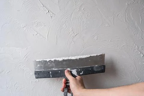 Applying decorative putty. White abstract texture of surface covered with putty Stock Photos