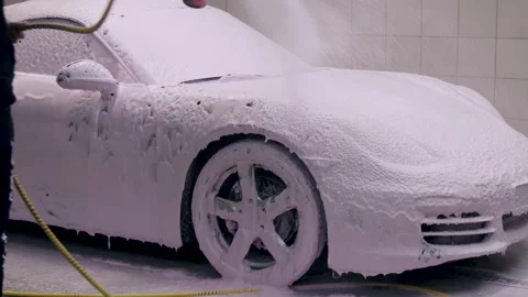 Applying detergent to auto with high-pressure foam sprayer Stock Footage 194230187