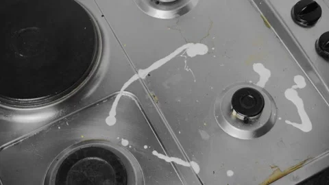 Applying detergent to a dirty stainless steel stove and wiping with a sponge Stock Footage 334882010