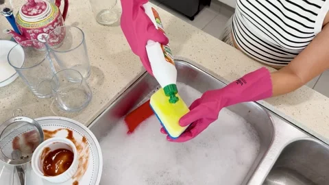 Applying Dish Soap to Sponge Before Washing Dirty Dishes Vídeos de archivo 313270311