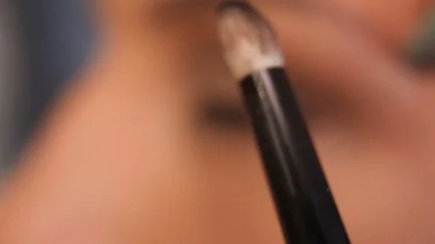 Applying eye shadow to eye creases with a brush Stock Footage 81284346