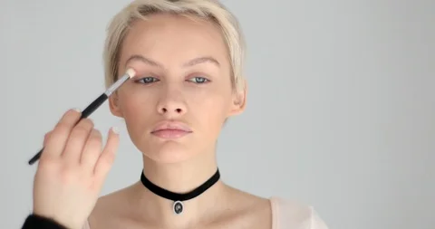 Applying eye shadows eyelid eyebrows with makeup brush close-up face 4k Stock Footage 90929074